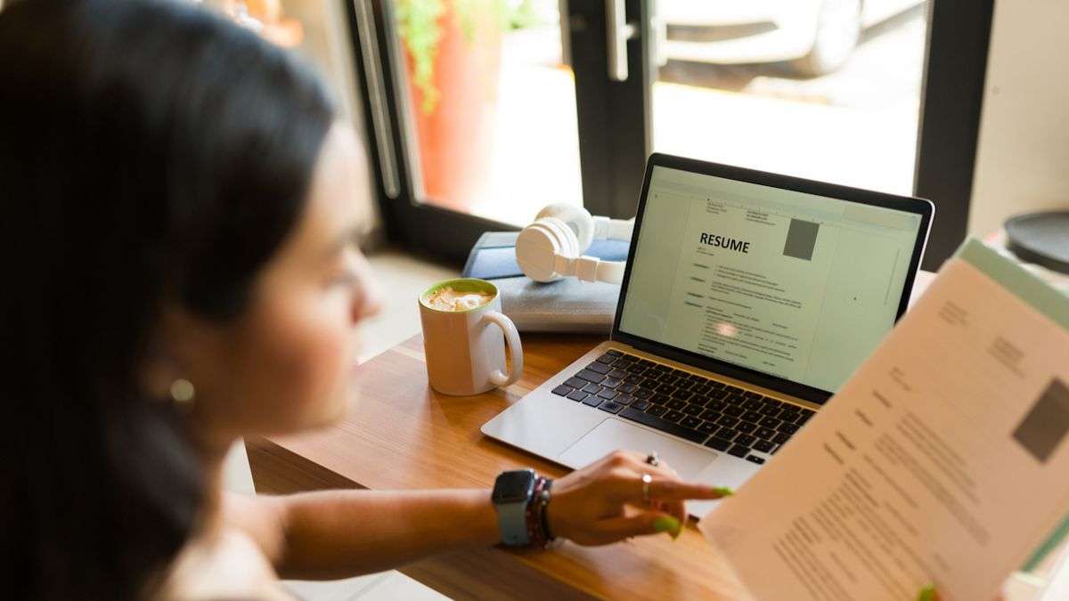 Une femme rédigeant son CV dans un café 