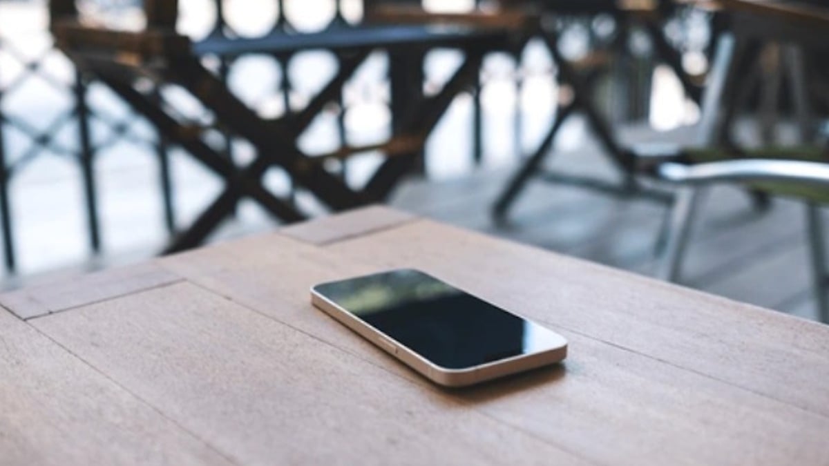 Téléphone portable posé sur une table en bois