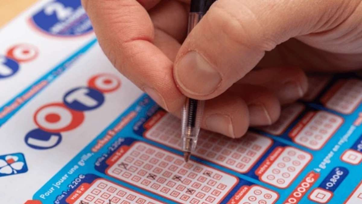 Un homme en train de remplir une grille de Loto