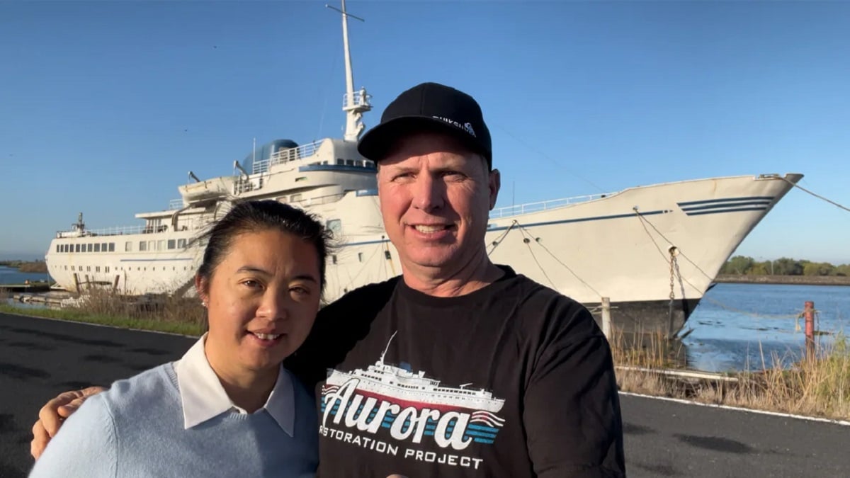 couple posant devant le bateau qu'il rénove