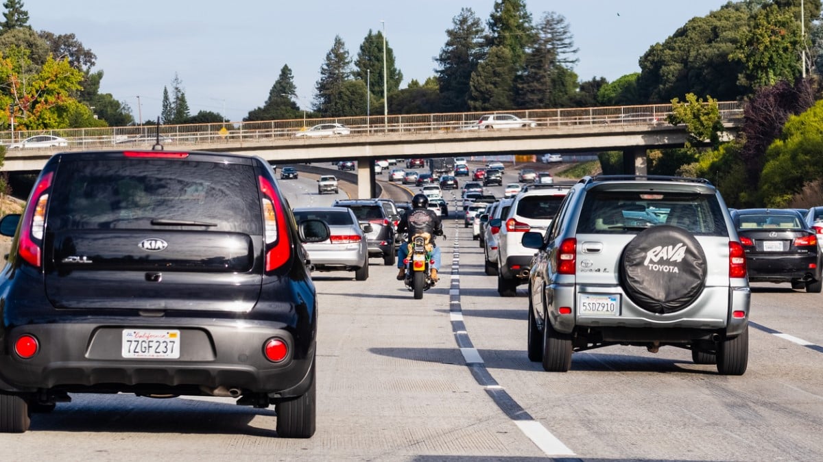 Un motard roule entre les voitures