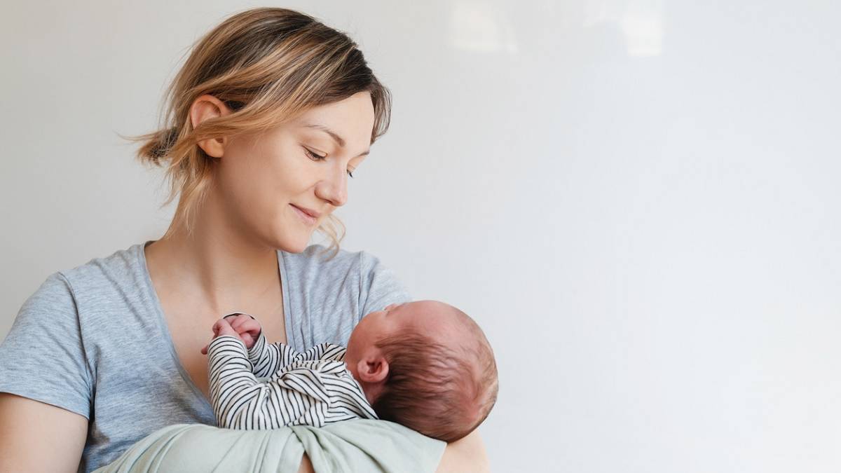 une femme portant son bébé dans les bras