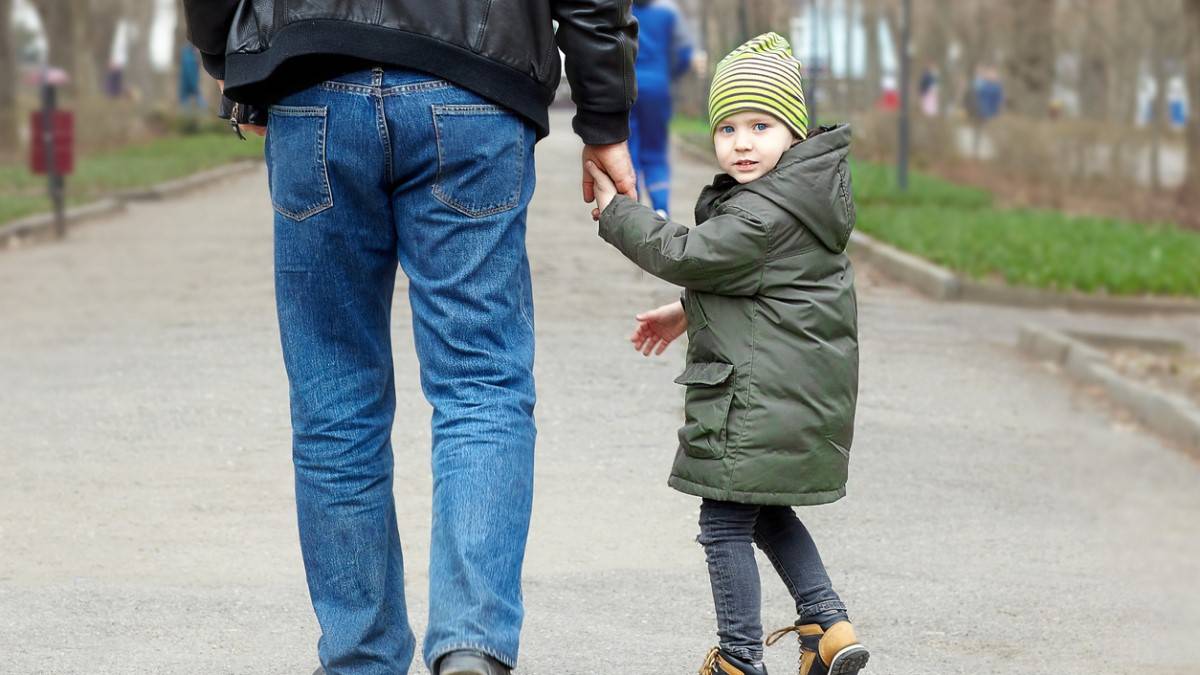 Un enfant part en tenant la main d'un homme