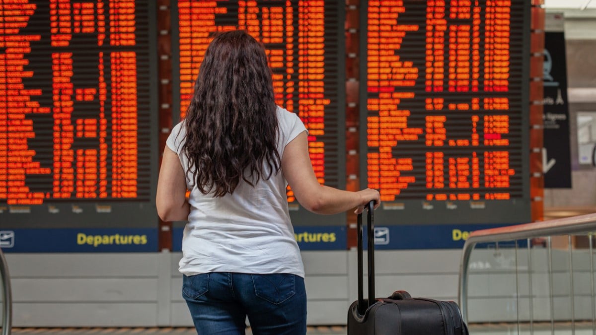 Une femme s'informe sur les vols à l'aéroport