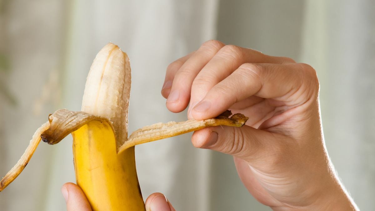 Une personne qui épluche une banane 