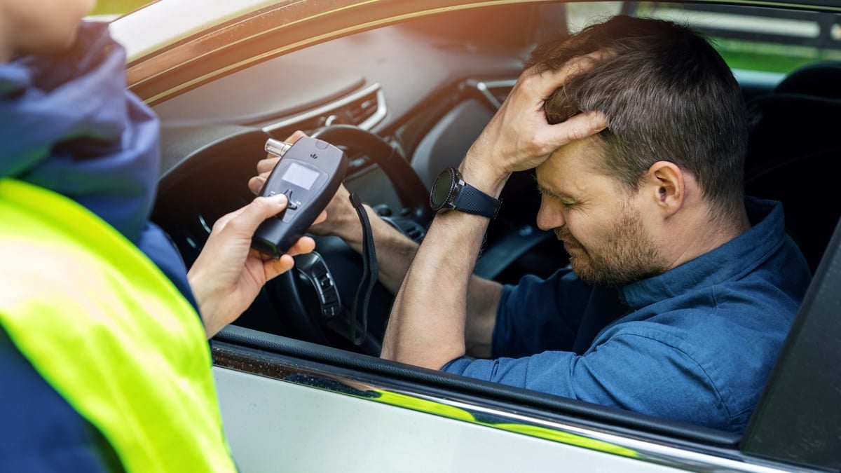 conducteur se prenant le visage dans la main devant un contrôle de police