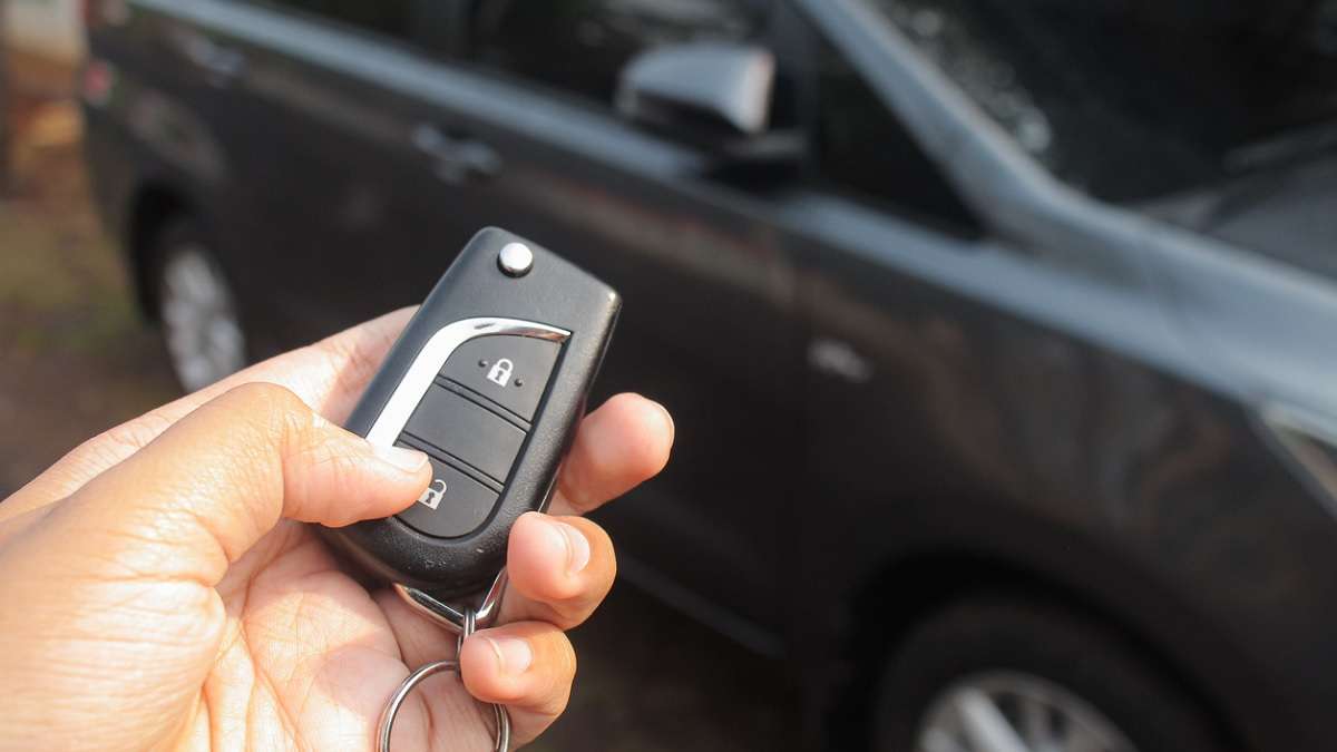 conducteur appuyant sur la télécommande de la voiture