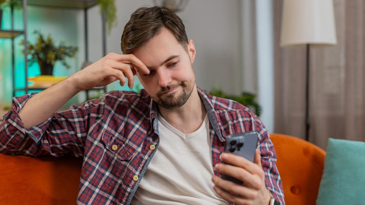 Un homme déçu devant son téléphone