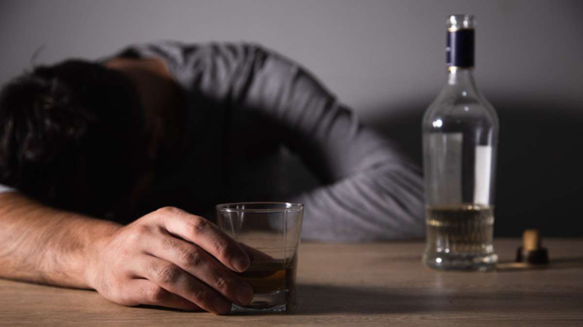 Un homme, fortement alcoolisé, dort sur une table