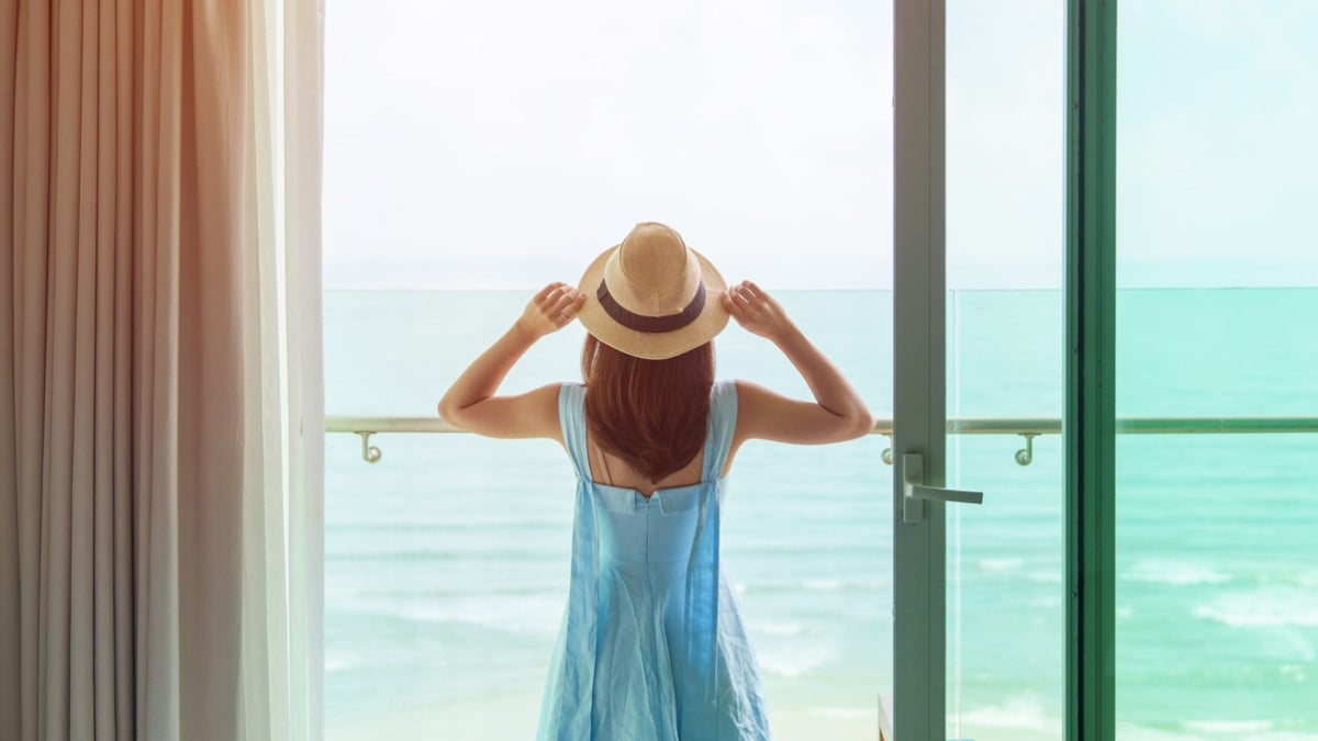 Une femme face à la mer depuis son logement