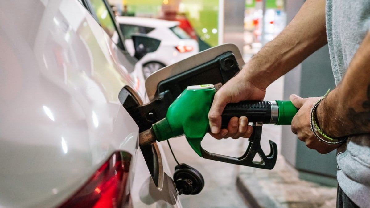 Un homme met de l'essence dans sa voiture