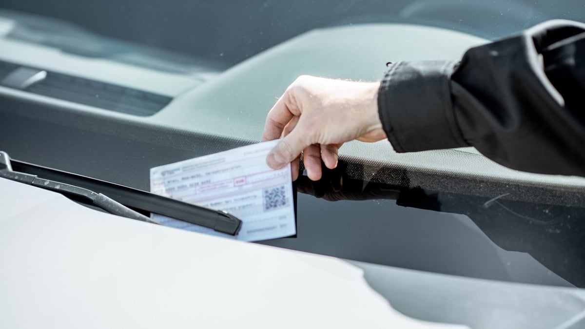 un policier mettant une amende sur une voiture