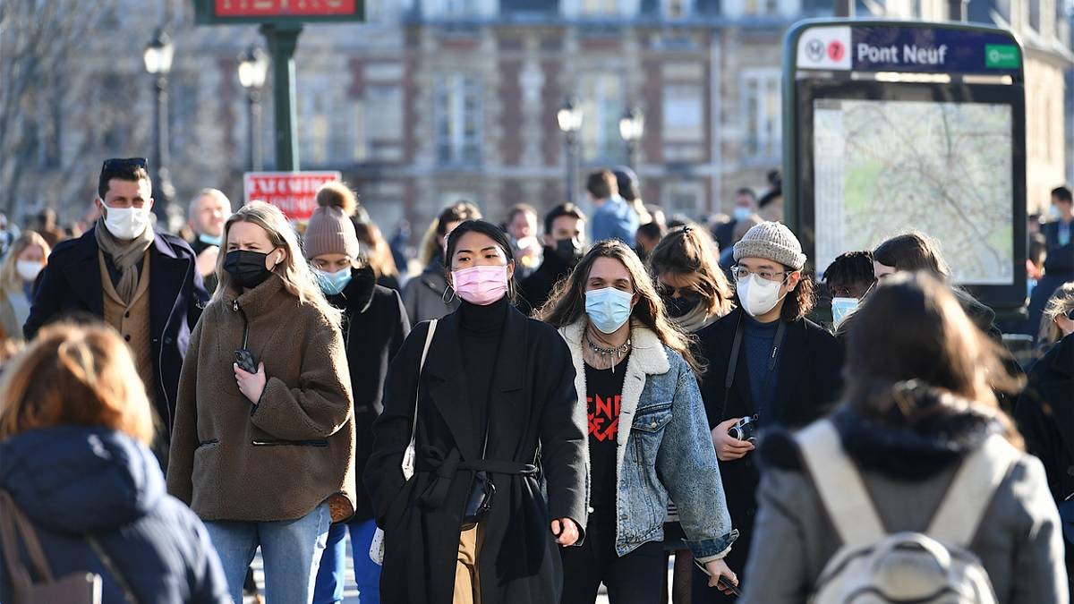 foule de personnes portant un masque dans les rues de Paris