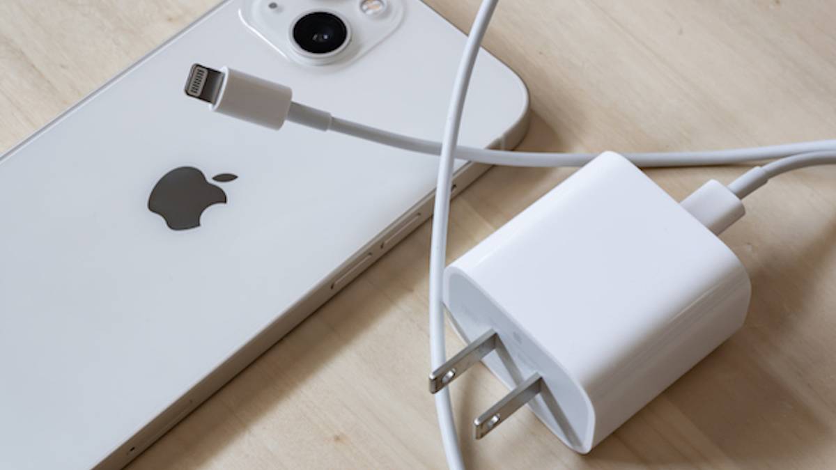 Un iPhone 13 avec adaptateur secteur 20W et câble Lightning 