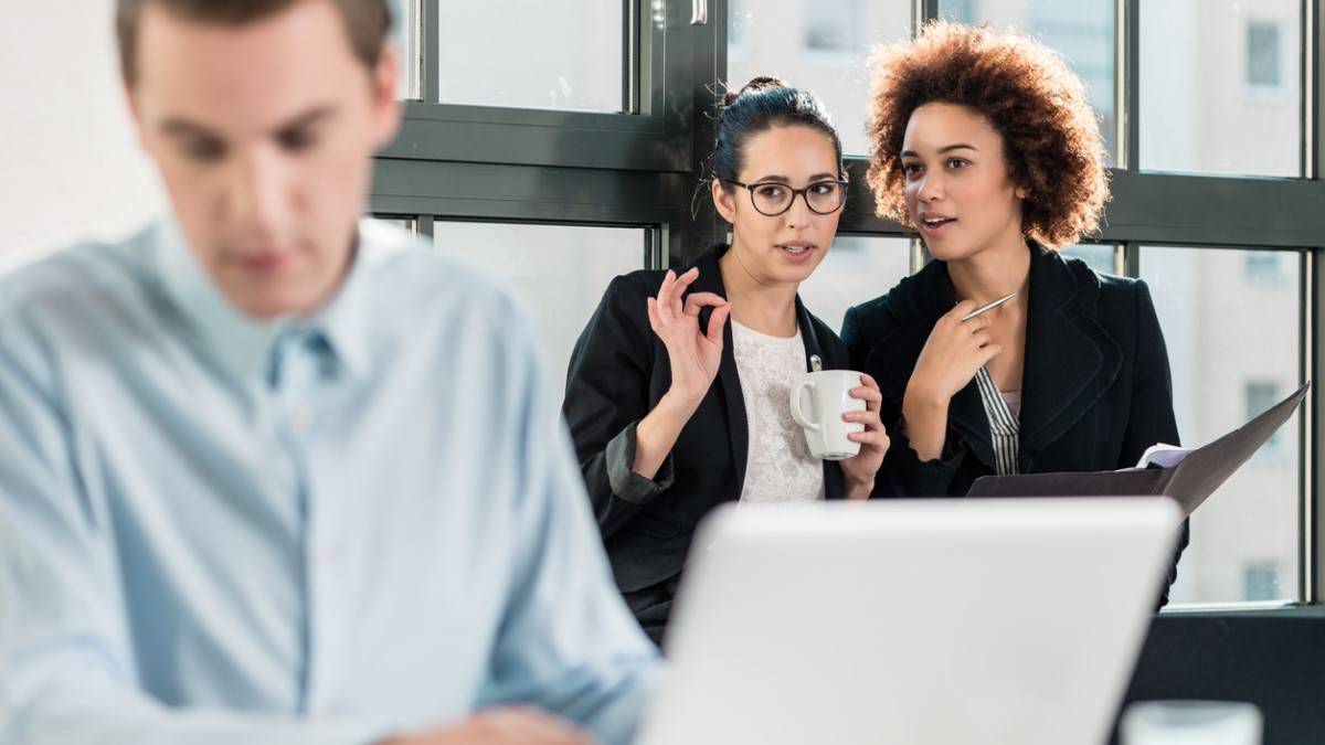 Deux femmes critiquent un homme au travail