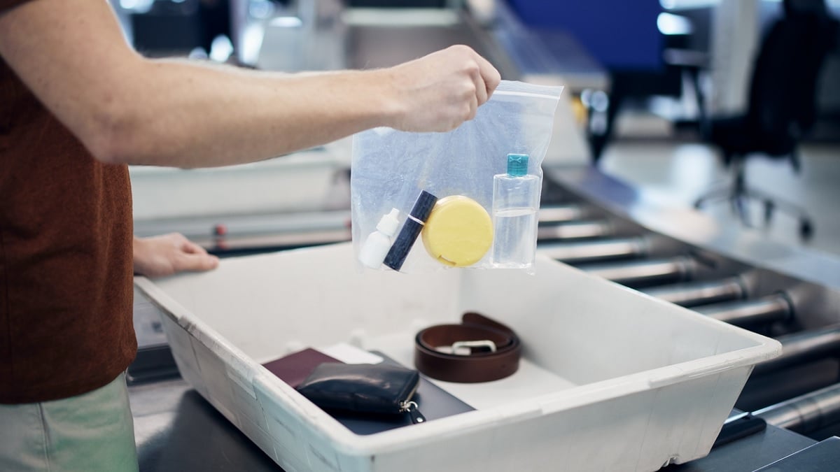 passager montrant ses affaires lors d'un contrôle de sécurité à l'aéroport