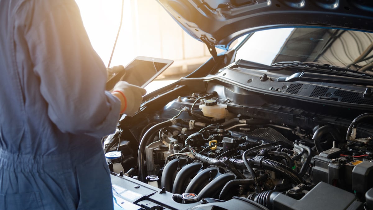 Un mécanicien en train de vérifier l’état d’une voiture dans un garage 