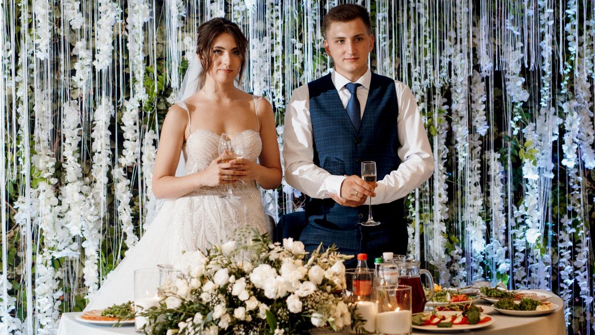 Un couple de jeunes mariés avec des verres à la main