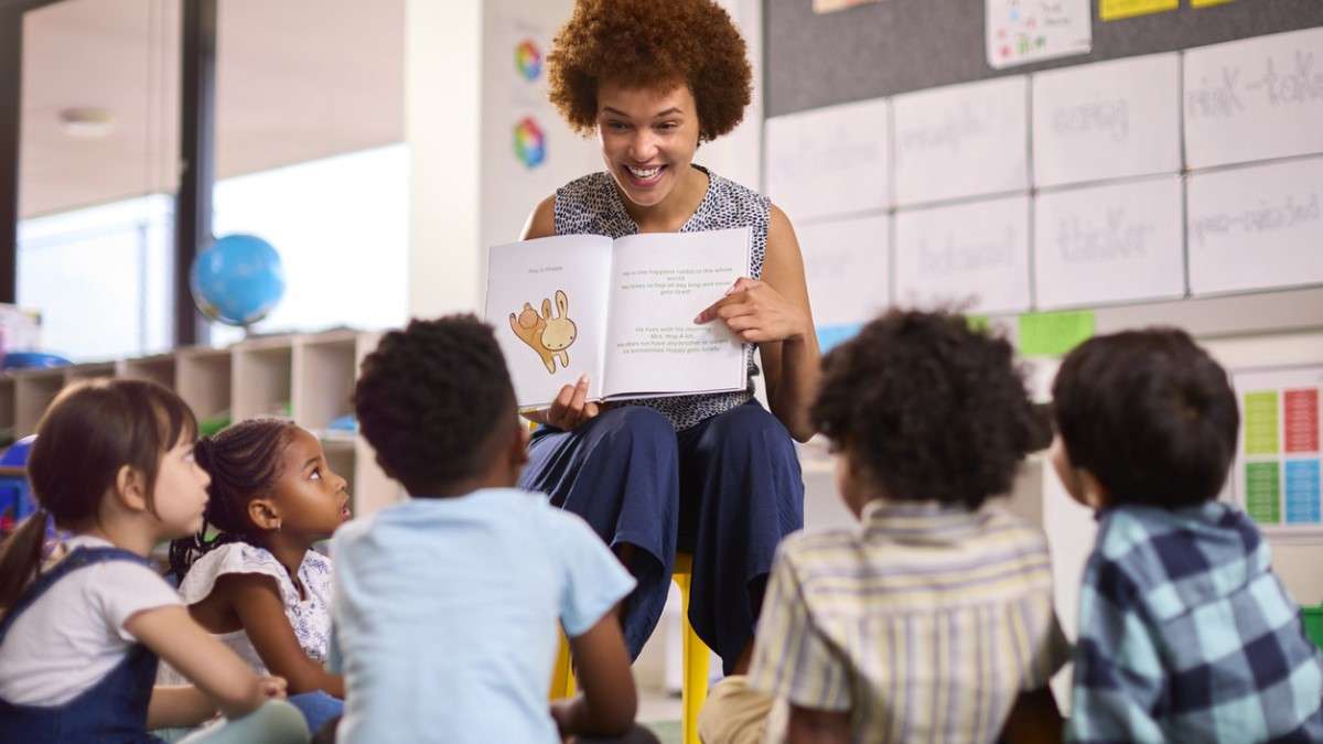 Une enseignante montre un livre à des enfants