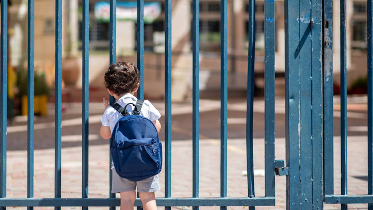 Un enfant devant la porte de son école