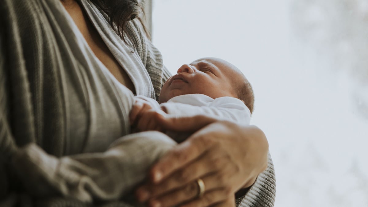 maman portant son nouveau-né dans les bras