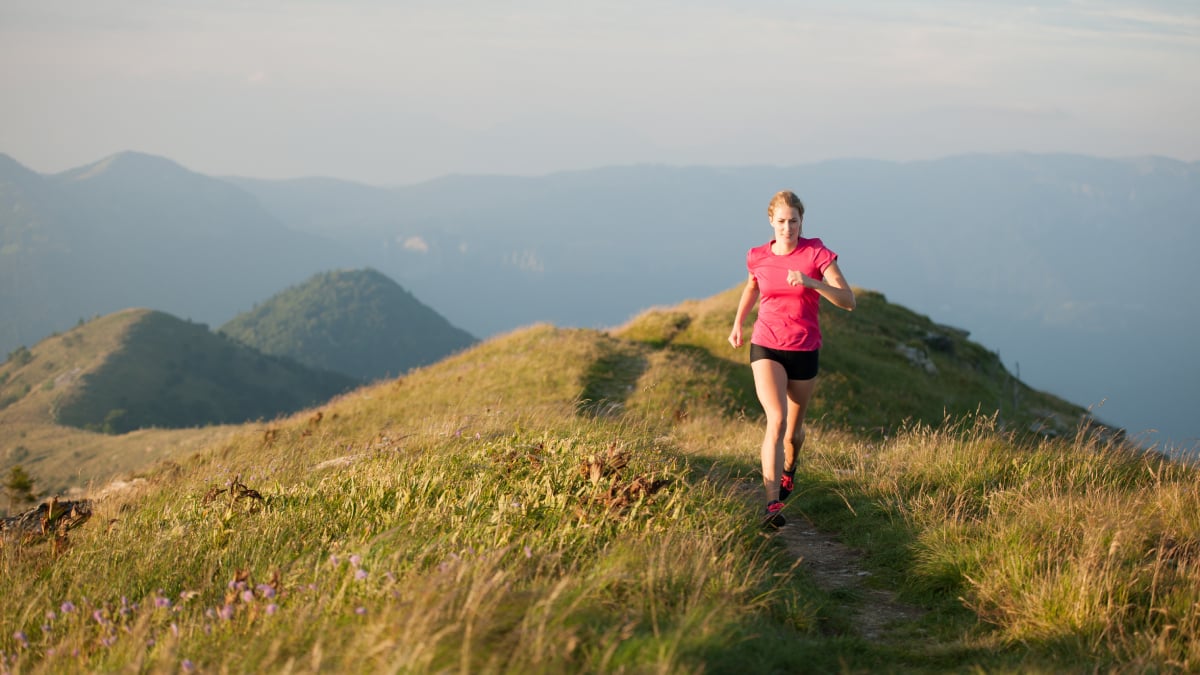 Une femme court sur une colline