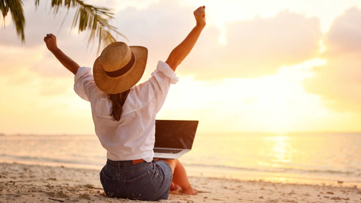 Une femme avec un ordinateur sur la plage