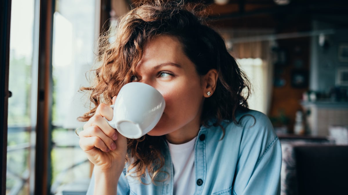 Une femme boit un café