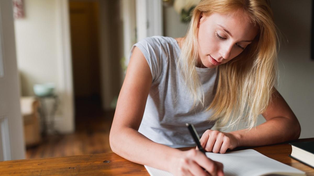 jeune femme écrivant dans un carnet