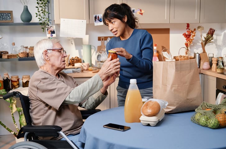 Une jeune femme aide une personne âgée.
