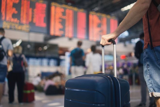 Un passager regarde le panneau d'affichage à l'aéroport