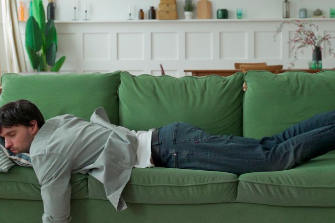 un homme endormi dans son canapé