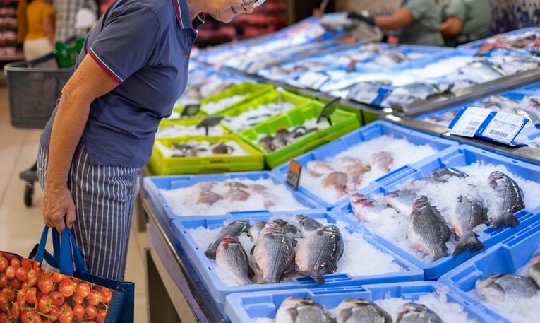 Femme achetant du poisson au supermarché 