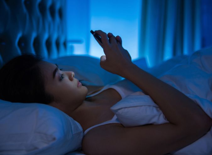 Une femme le soir sur son smartphone