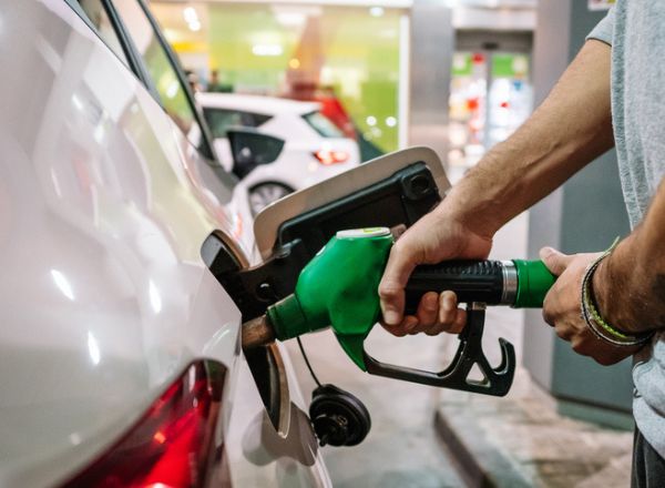 un conducteur met de l'essence à la pompe dans une station-service