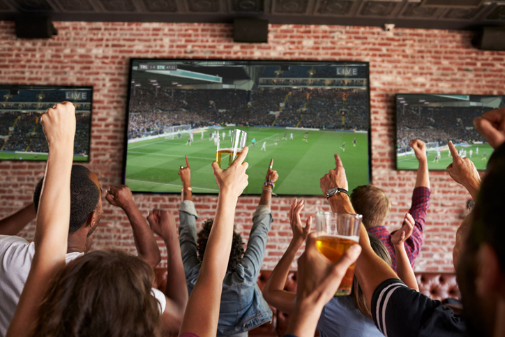 Des personnes regardent un match de foot dans un bar