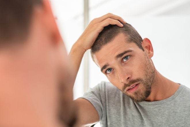 Un homme regarde ses cheveux