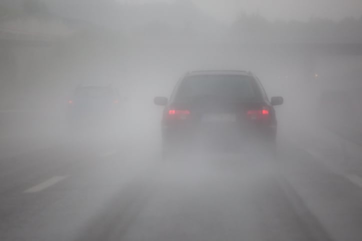 Une voiture sur la route dans le brouillard