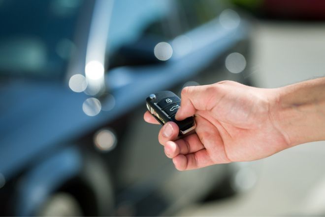 une personne déverrouille sa voiture avec sa clé