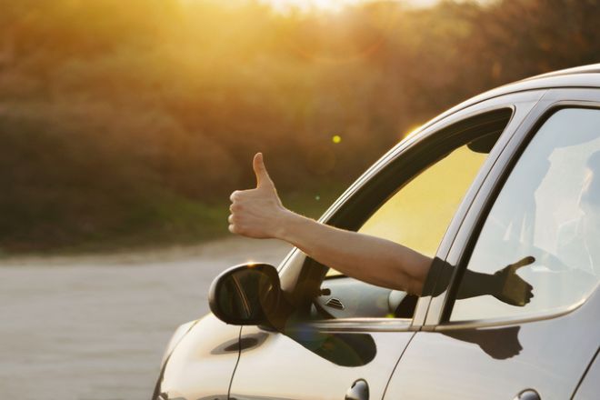 un homme lève le pouce par la fenêtre de sa voiture