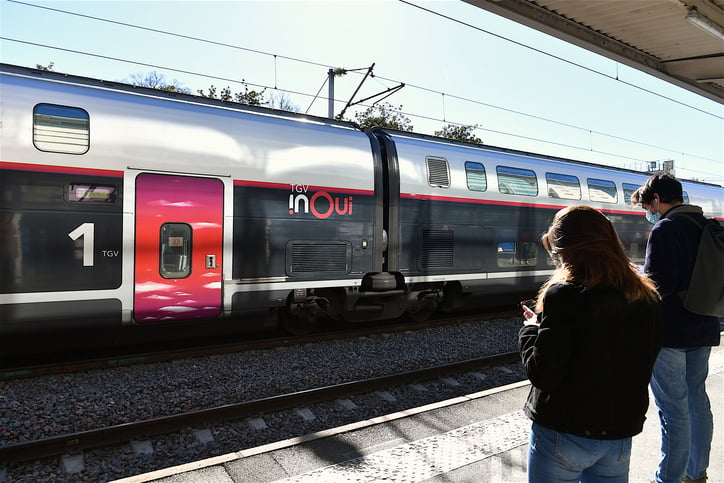 Des voyageurs attendent un train sur le quai de la gare