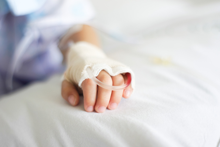 Enfant malade et perfusé sur un lit d'hôpital