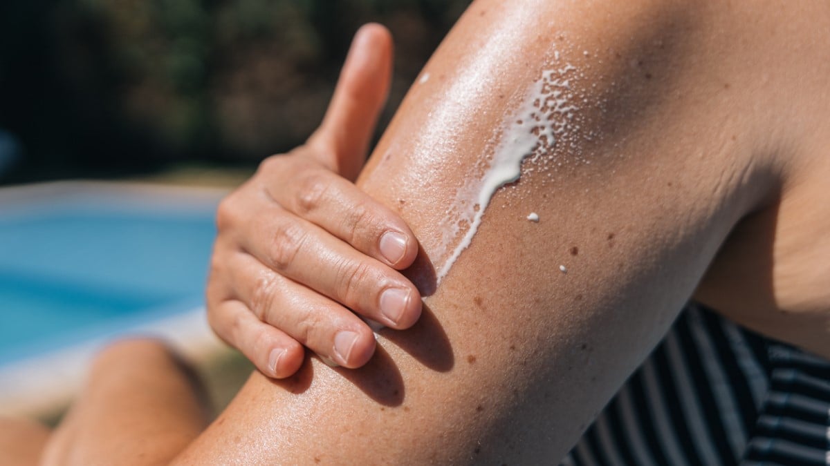 Une personne se met de la crème solaire sur le bras