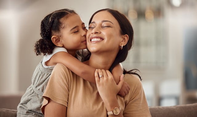 Une petite fille en train d’enlacer sa maman 