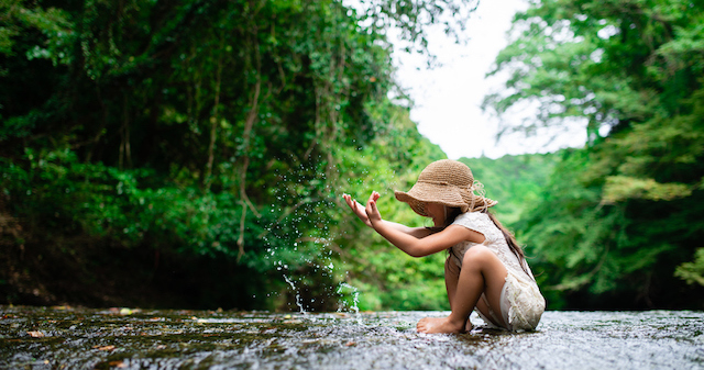 Une petite fille jouant dans un ruisseau 