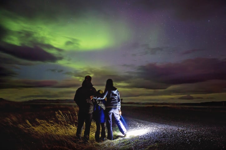 Une famille observe une aurore boréale