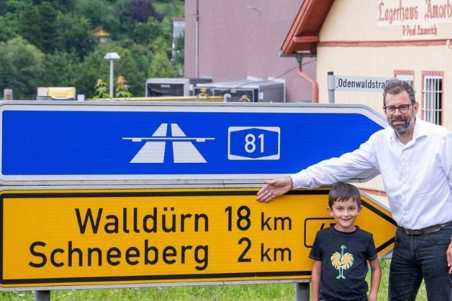 Valentin Weiss et son père devant le panneau de signalisation modifié