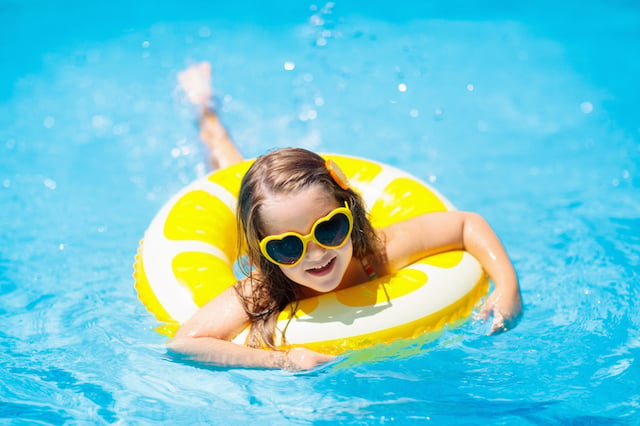 Une petite fille en train de s'amuser dans une piscine