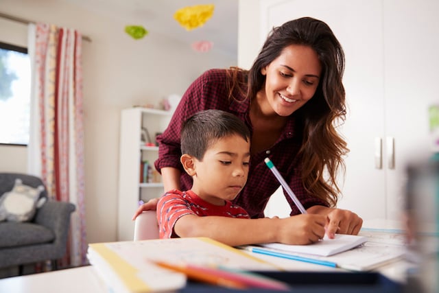 Un enfant en train de faire ses devoirs avec sa mère