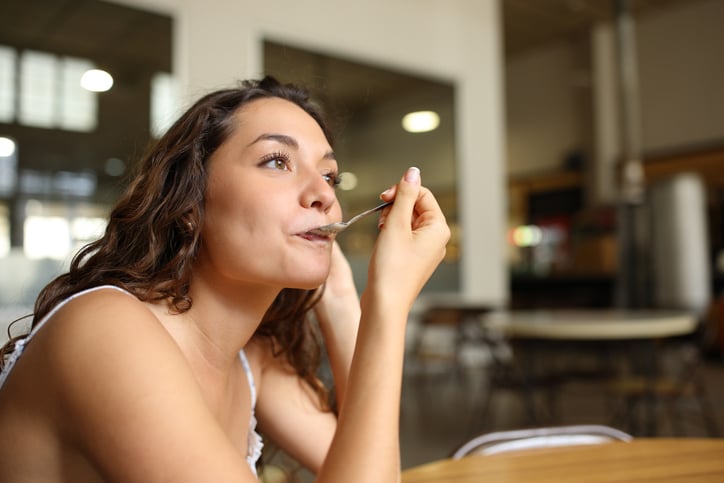 Une femme mange des céréales au petit-déjeuner